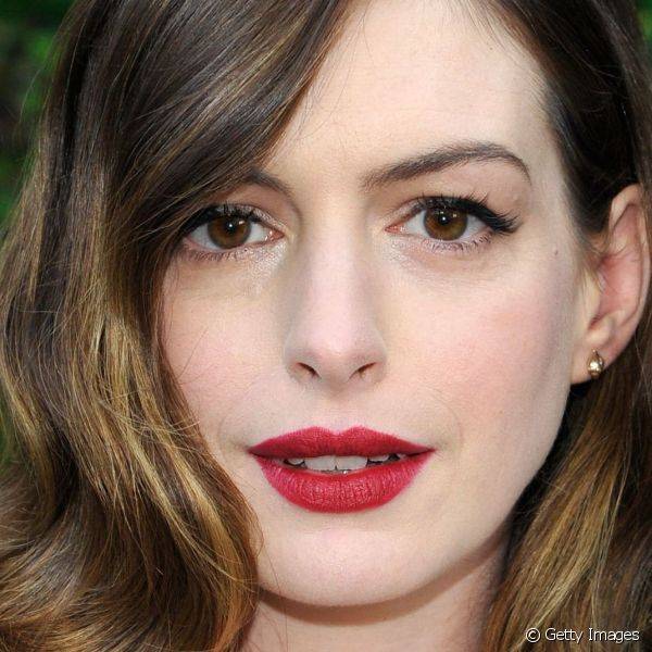 Anne Hathaway escolheu uma das combina??es de make mais cl?ssicas e elegantes: batom vermelho opaco e olhos delineados de preto